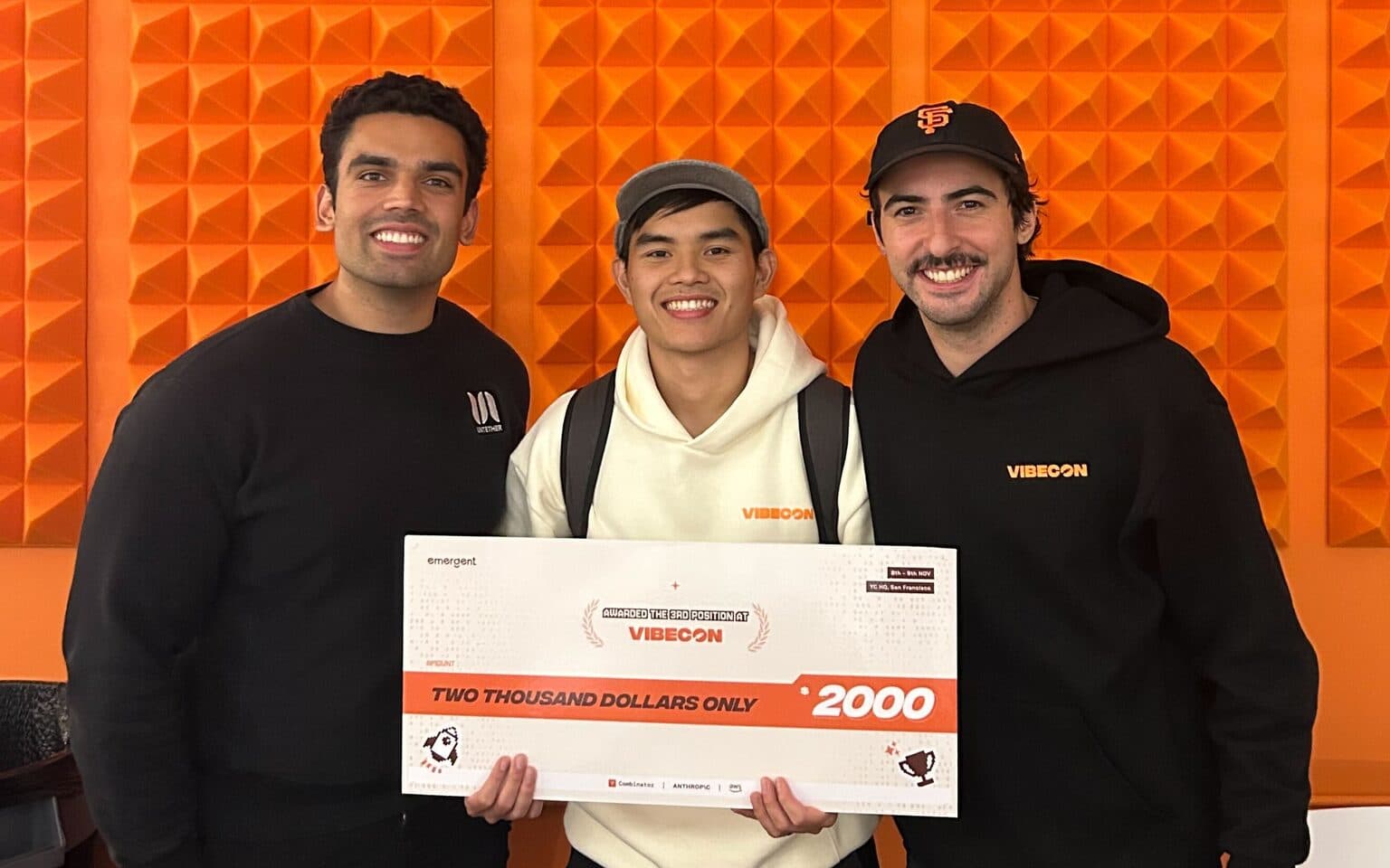 Satya, Kiet, and Avi hold a $2,000 prize check at Vibecon