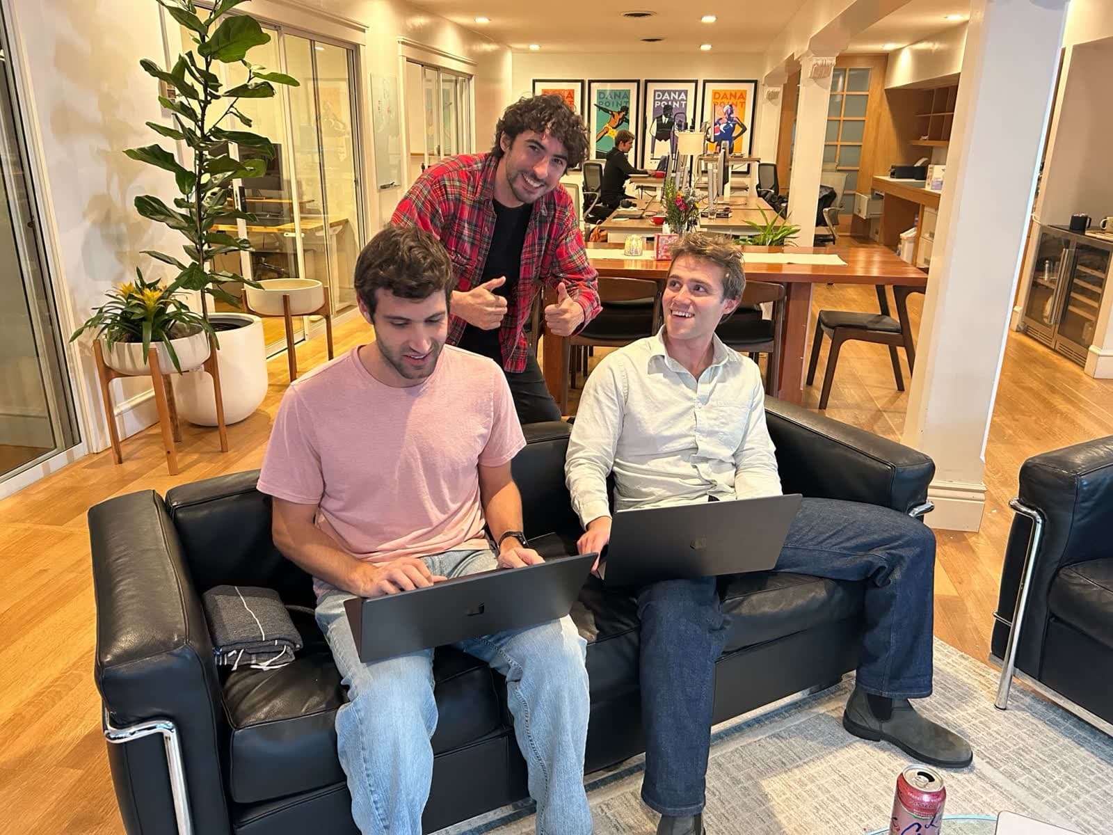Avi gives a thumbs up while two early users try Paradev on their laptops in their office