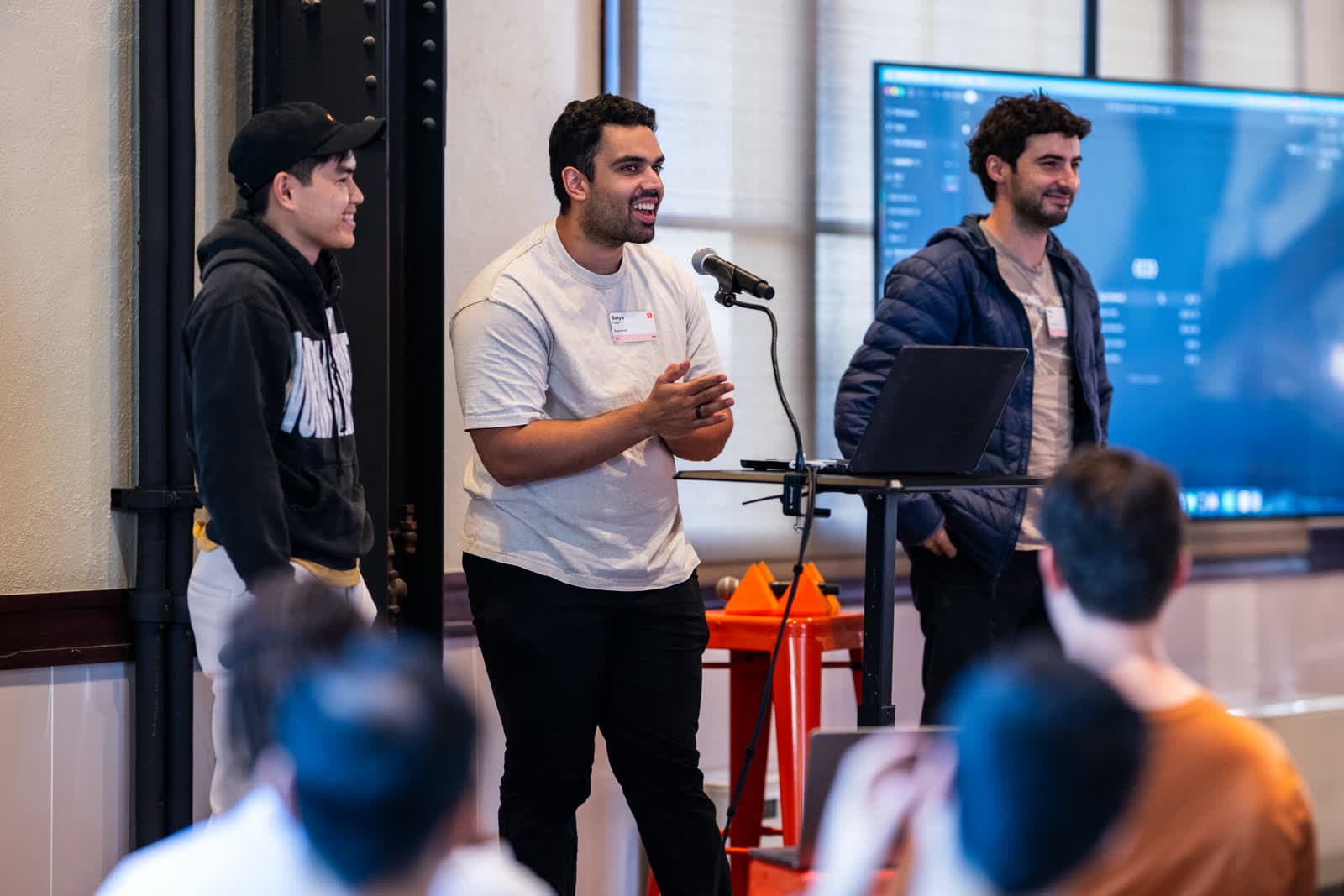 Kiet, Satya, and Avi on stage presenting Paradev at a Y Combinator event